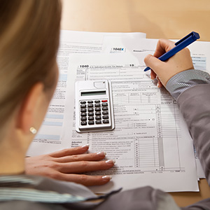 woman sitting at desk filling out paperwork with calculator layton ut